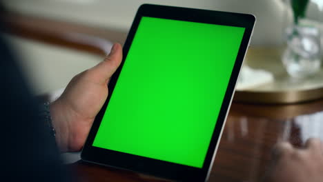 manos del trabajador con la tableta de pantalla verde en primer plano. hombre exitoso usando maqueta