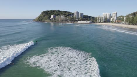Surfers-In-The-Sea-With-Foamy-Waves-At-Burleigh-Beach-In-Queensland,-Australia