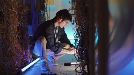 male asian system administrator working in server room