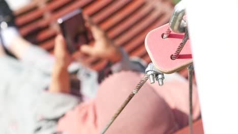 woman using smartphone while working at height with safety equipment