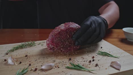 chef seasons raw fresh tenderloin steak on a wooden cutting board, slow motion, close up