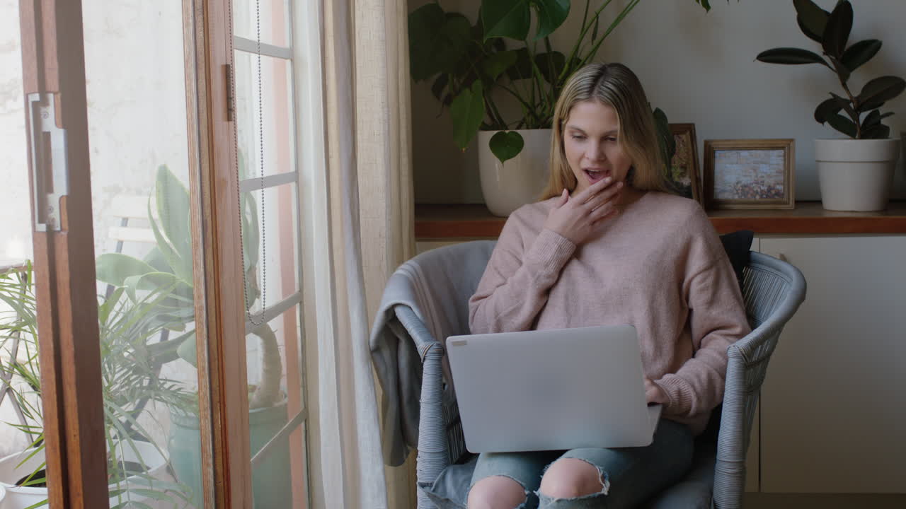 mujer joven feliz usando una computadora portátil trabajando desde casa navegando en línea viendo entretenimiento disfrutando relajándose el fin de semana