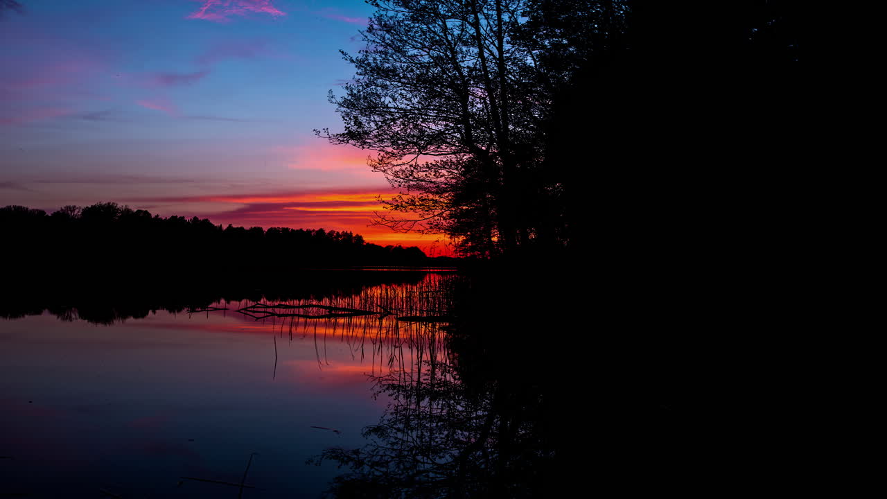 Sky with colorful clouds reflecting in lake at sunset