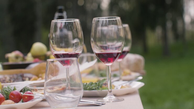 Close Up View Of Two Wine Glasses On A Table During An Outdoor Party In The Park