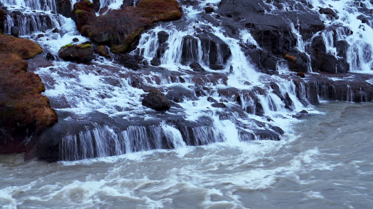 Cascade dévalant vers la rivière Hvita à travers des rochers moussus