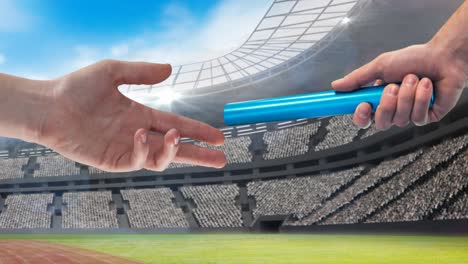 Animation-of-athlete's-hands-passing-blue-relay-baton-over-sports-stadium