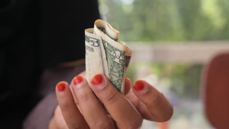 una mujer con un billete de cinco dólares.