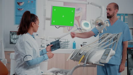 dentist receiving teeth scan from man while looking at green screen