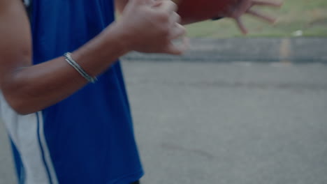 young handsome man practicing with a basketball on outdoor court