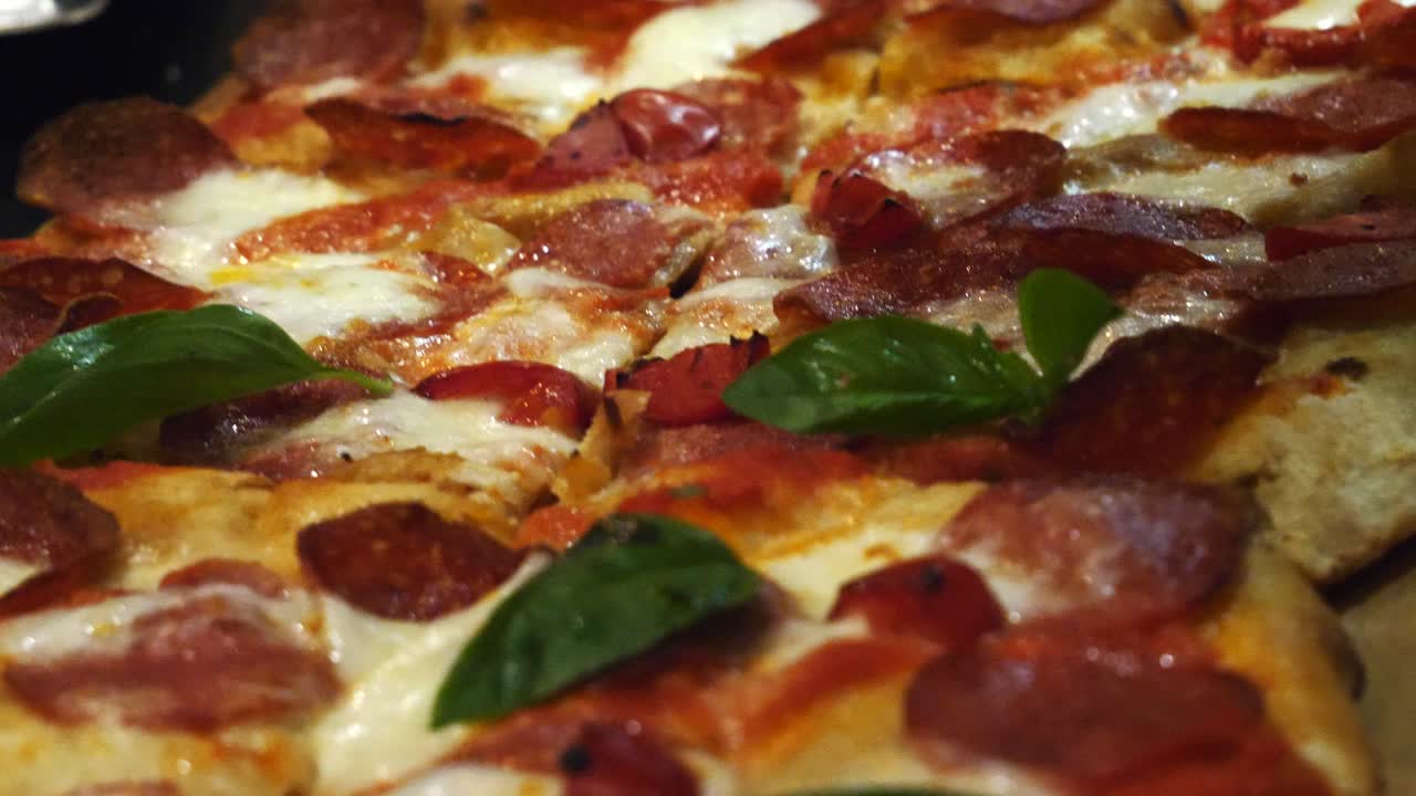 una deliciosa pizza con pepperoni y albahaca