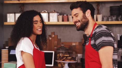 camarero y camarera sonriendo en la cafetería