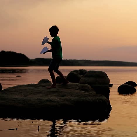 boy playing on stony beach