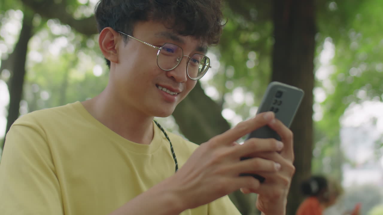 Asian Zoomer Using Smartphone in Park