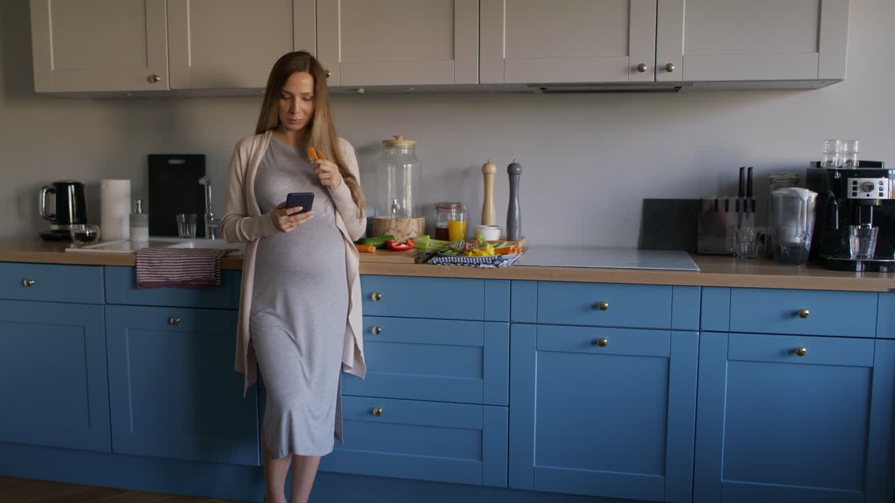 Donna incinta che mangia cibo sano e usa il cellulare
