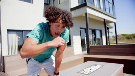 a young biracial man is wiping sweat from his forehead