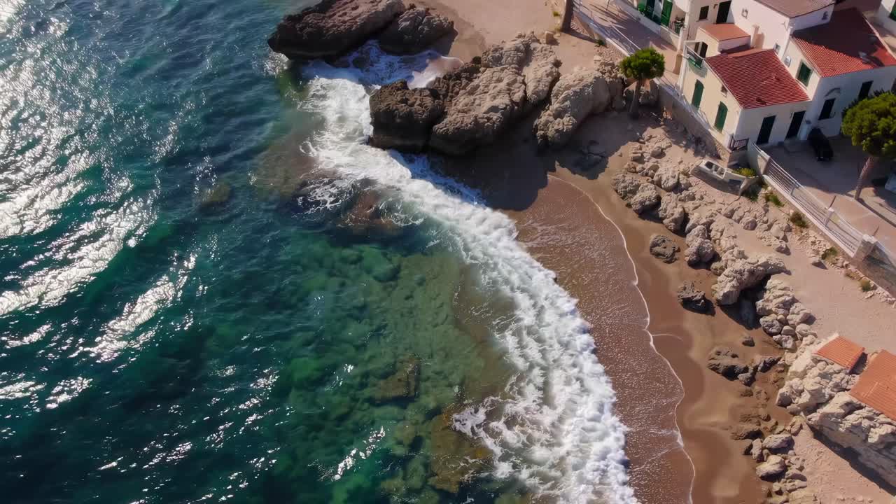 Dronevideo viser en kystlandsby med hvide huse og røde tage.