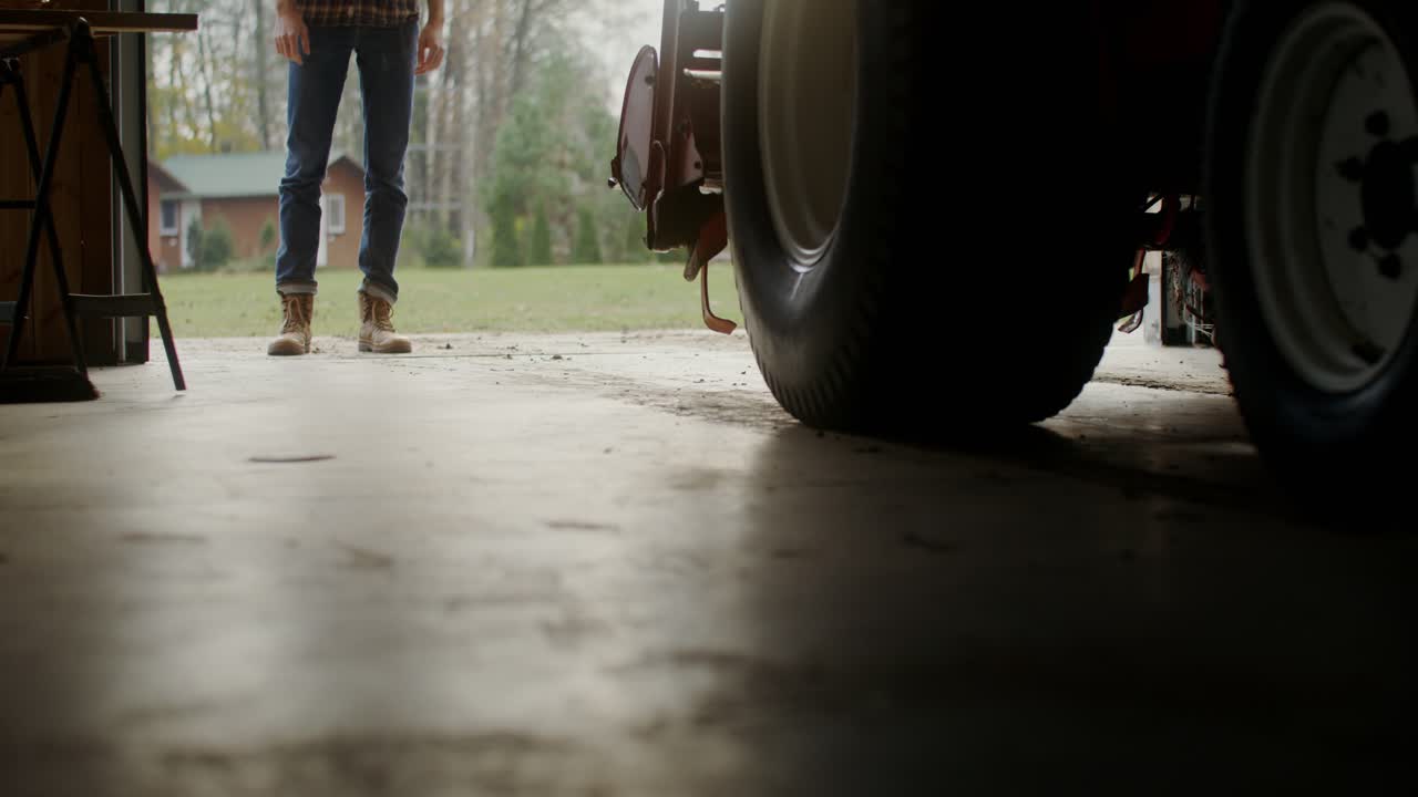 agricultor trabajando en un garaje con un tractor