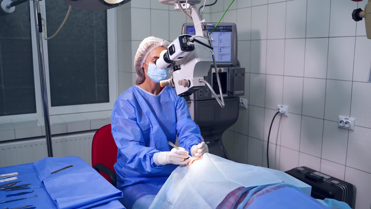 Ophthalmologist looks in the microscope. Surgeon with ophtalomological tools during surgical treatment