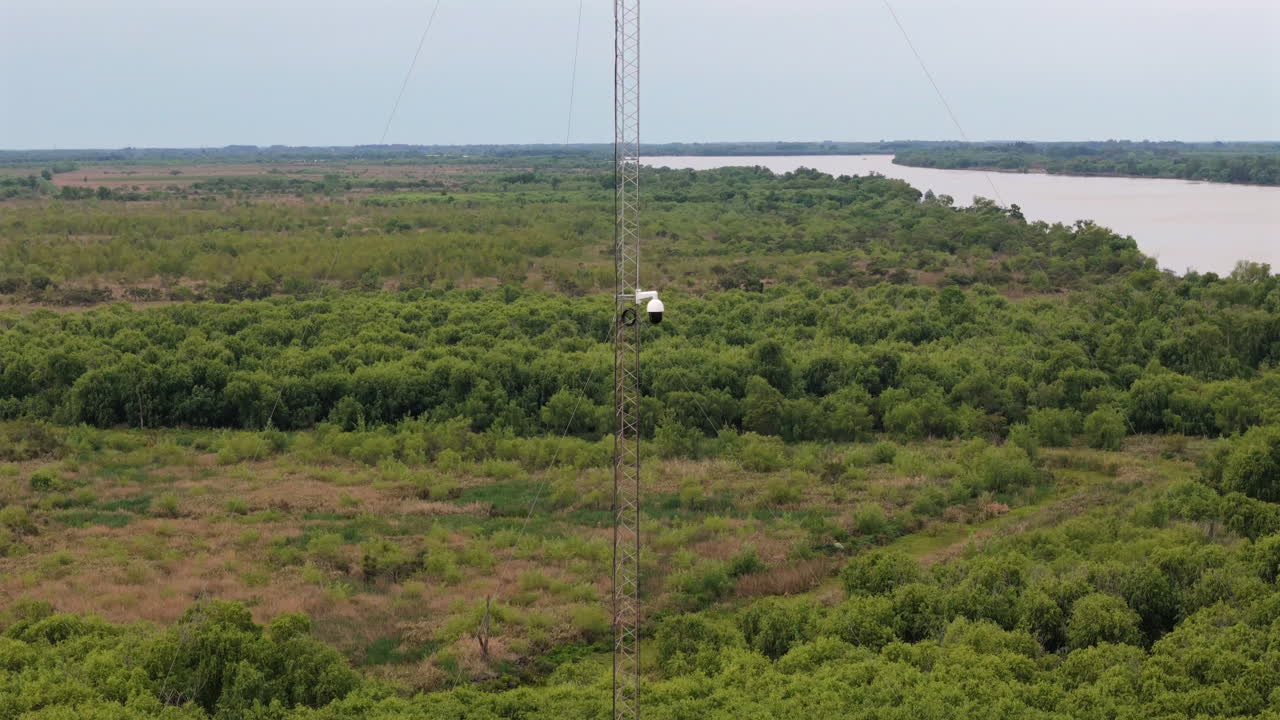 tall surveillance tower stands over the Paraná Delta near the Río Uruguay, monitoring wetlands for environmental and border security purposes, drone orbiting shot