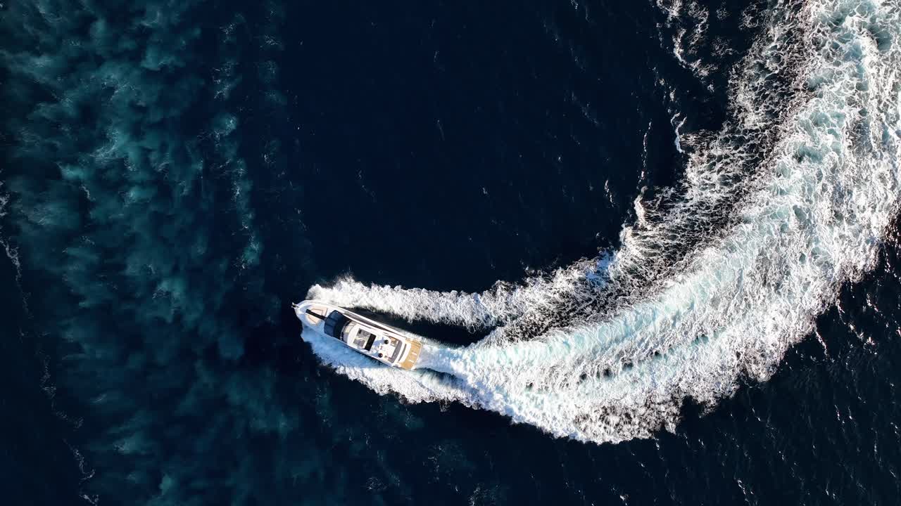 Top down drone shot of luxury yacht driving at sea