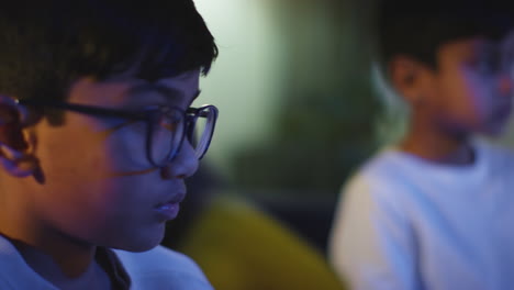 Close-Up-Of-Two-Young-Boys-At-Home-Playing-With-Computer-Games-Console-On-TV-Holding-Controllers-Late-At-Night-8