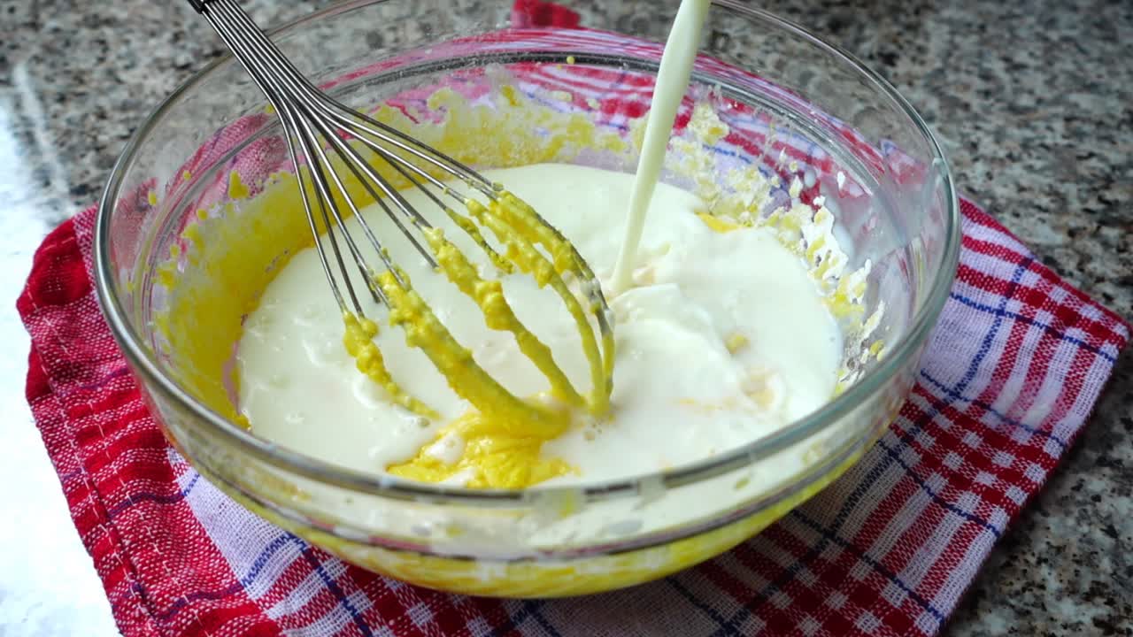 Aggiunta di latte nei tuorli. Preparazione della frittata. Slow motion