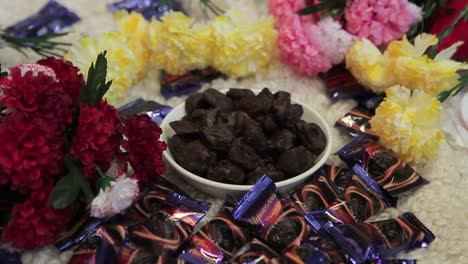 woman selecting chocolate treats amongst colorful flowers