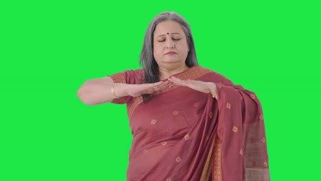 Relaxed-Indian-old-woman-doing-breathe-in-breathe-out-exercise-Green-screen