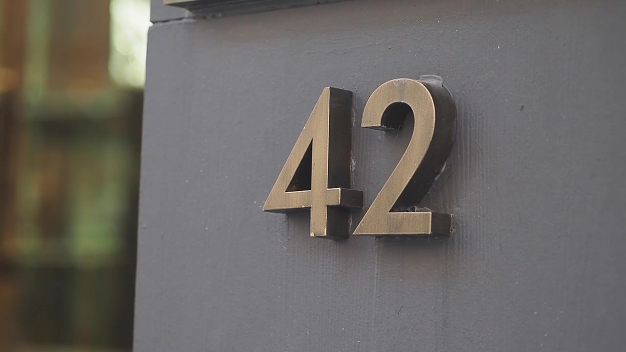 Metal House Number Forty Two Mounted on a Grey Wall