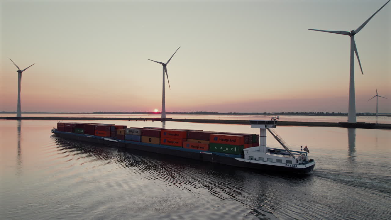 Cargo Ship Sailing Along The Wind Turbines At Krammer Lake During Sunset In Bruinisse, Netherlands. - aerial shot