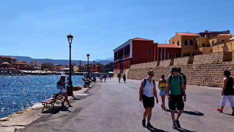 tourists crowding the old town promenade in chania’s historic harbor