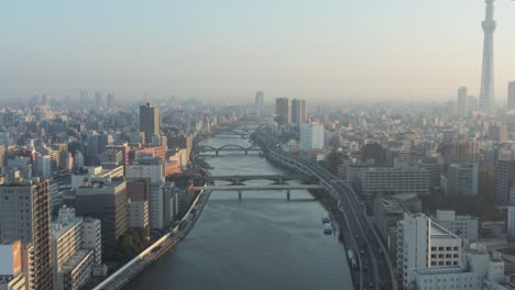 tokyo aerial tilt establishing shot of sumida river at sunrise 4k