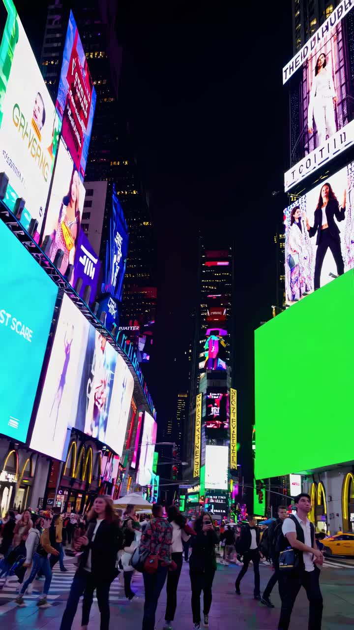 Video vibrante de paisaje urbano nocturno, mostrando imponentes vallas publicitarias digitales desde un ángulo a nivel de calle
