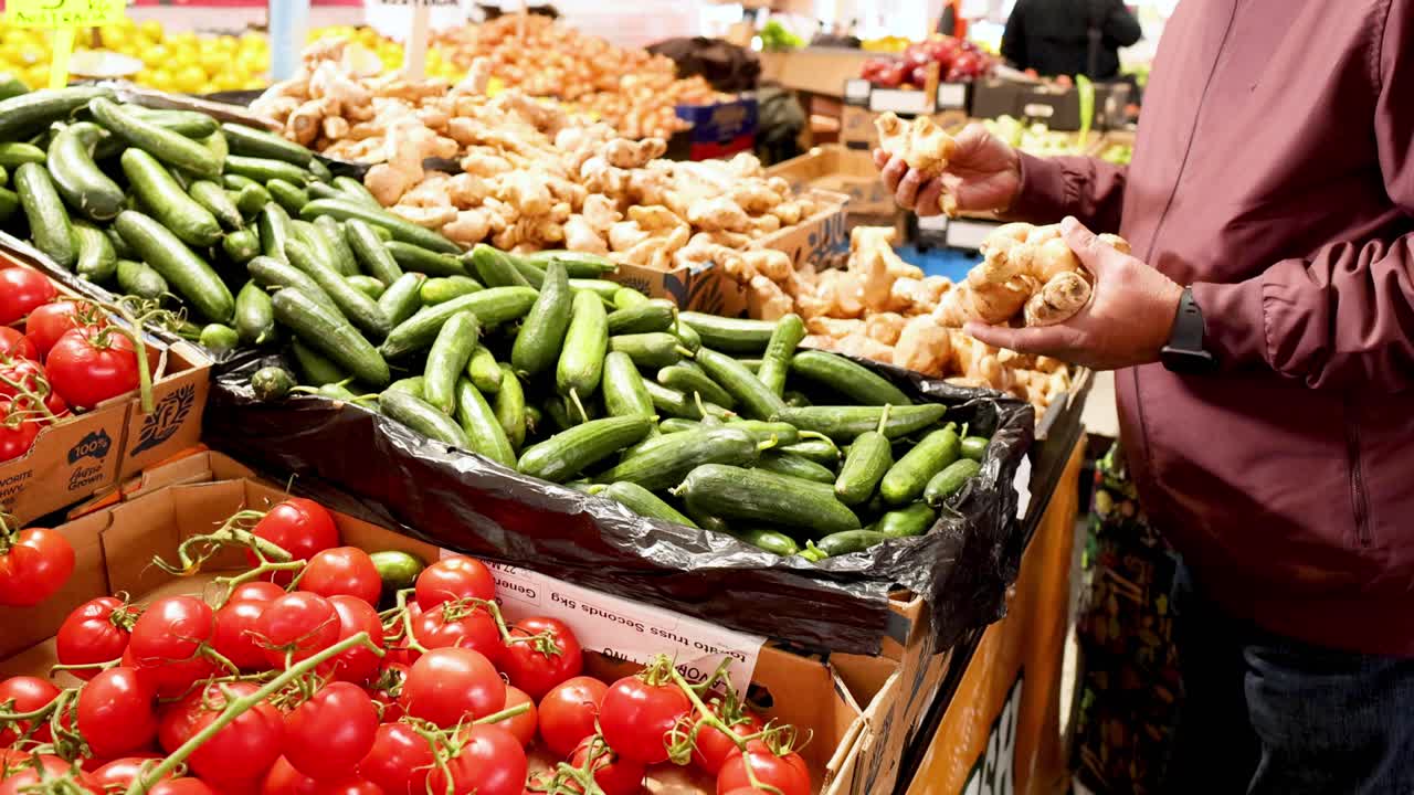 persona que selecciona verduras en el puesto del mercado