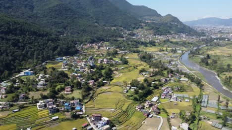 Eine-Luftschwenkansicht-Der-Stadt-Kathmandu-Mit-Den-Himalaya-bergen-Im-Hintergrund-Unter-Einem-Klaren-Blauen-Himmel-Und-Dem-Bagmati-fluss-Darunter