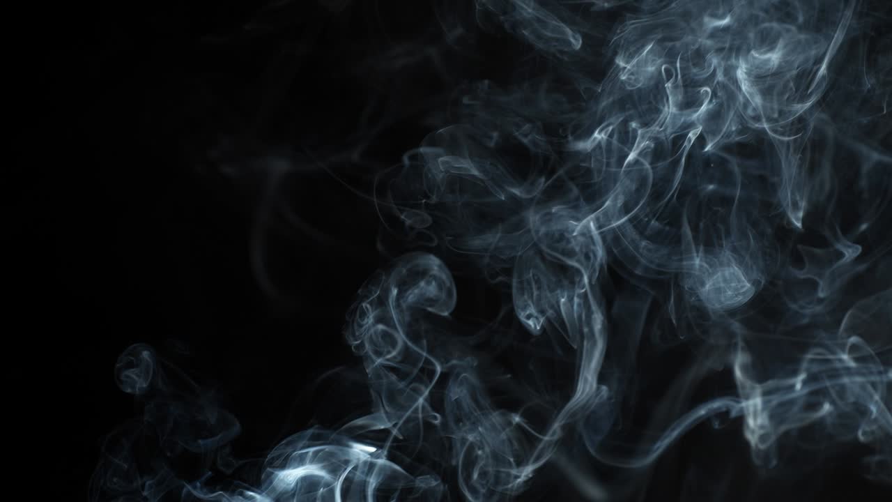 si alza fumo grigio su sfondo nero. il fumo si dissipa.