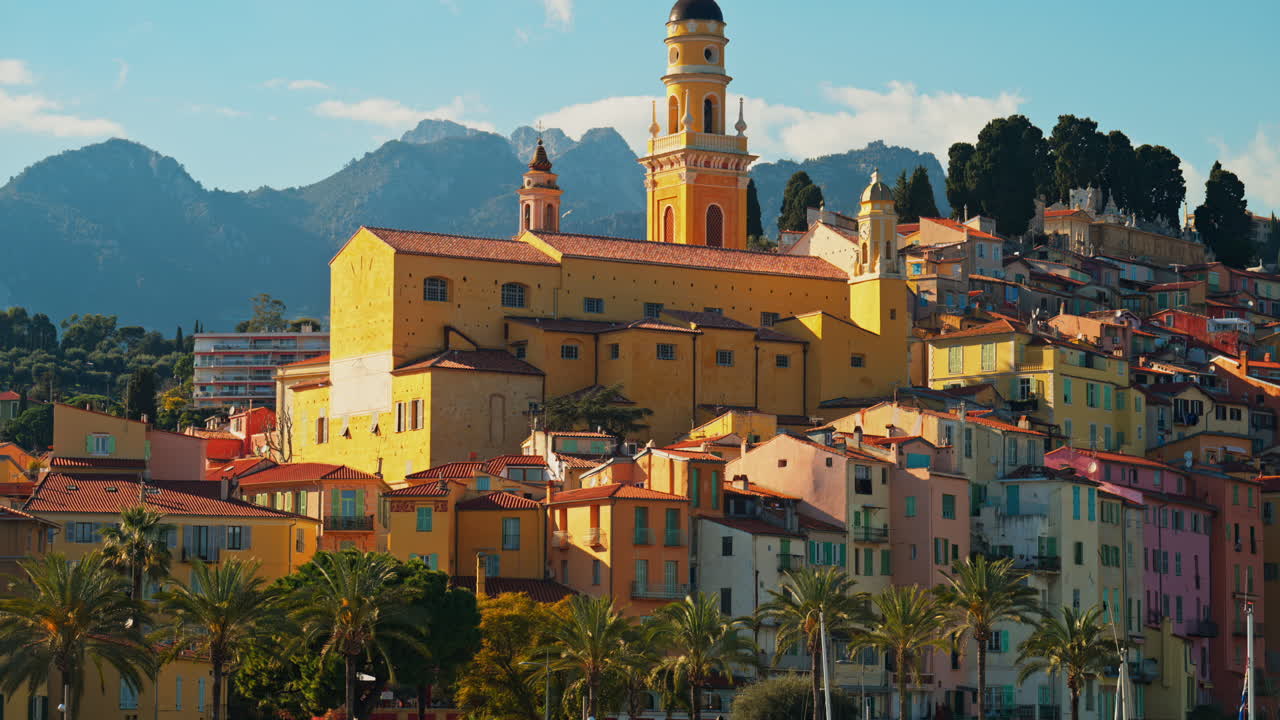 Distant view of the St Michel Basilica surrounded by colourful buildings, Menton, France