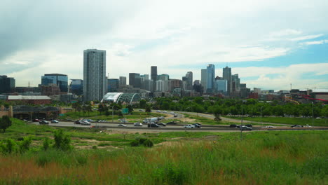 downtown denver i25 traffic rei ball arena south platte river elitch gardens cityscape with foothills rocky colorado cars traffic lush green summer cinematic pan to the left movement