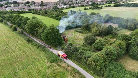 Firemen-putting-out-rubbish-fire-in-Essex-UK-aerial-fire-engine-parked-in-country-lane