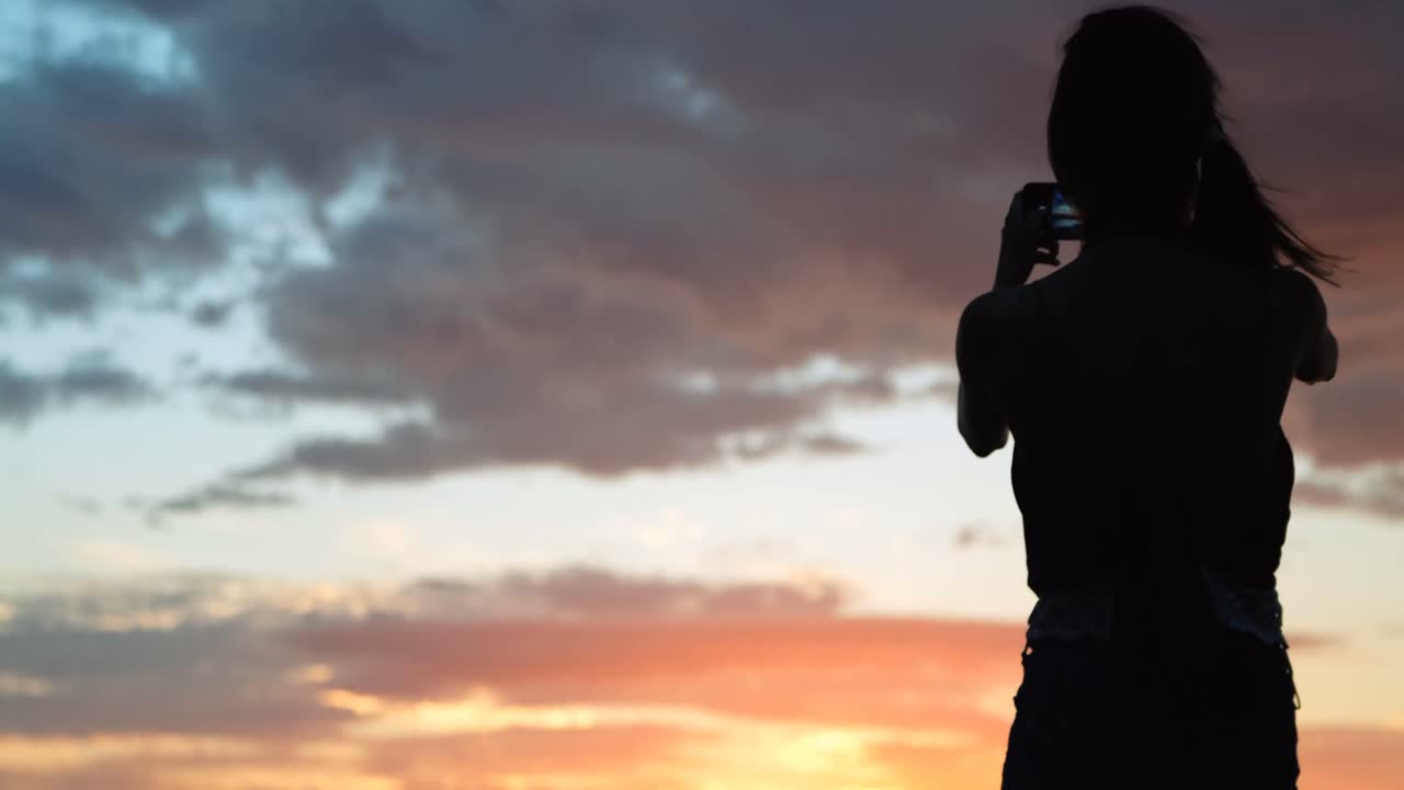 mujeres haciendo clic en fotos en la playa durante el atardecer 4k
