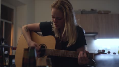 pretty blonde girl playing guitar, learning how to play home