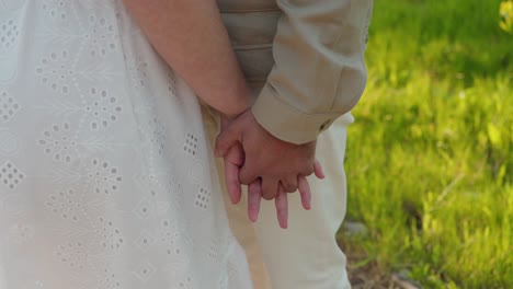 romantic moment of hands held tightly in warm outdoor light
