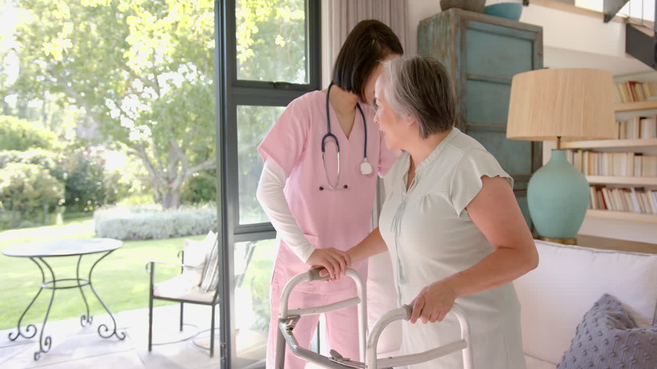 Helping senior asian woman with walker, nurse providing physical therapy at home