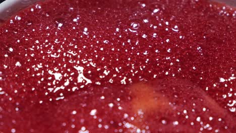 Close up of red liquid with bubbles