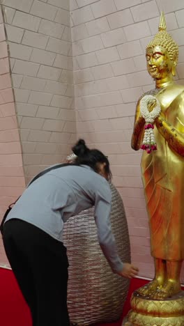 woman praying in front of buddha statue