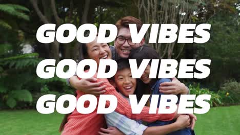 animation of good vibes text over smiling asian family embracing