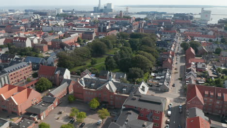 Birds-eye-of-Esbjerg,-Denmark,-with-building-made-of-brick.-Look-up-revealing-the-harbor,-one-of-the-most-important-in-the-north-sea-with-chimney-of-the-coal-and-oil-fueled-power-plant