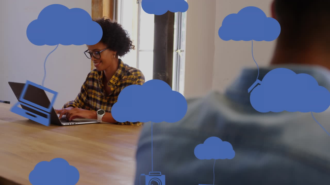 Animation of network of digital cloud icons over businesswoman in office
