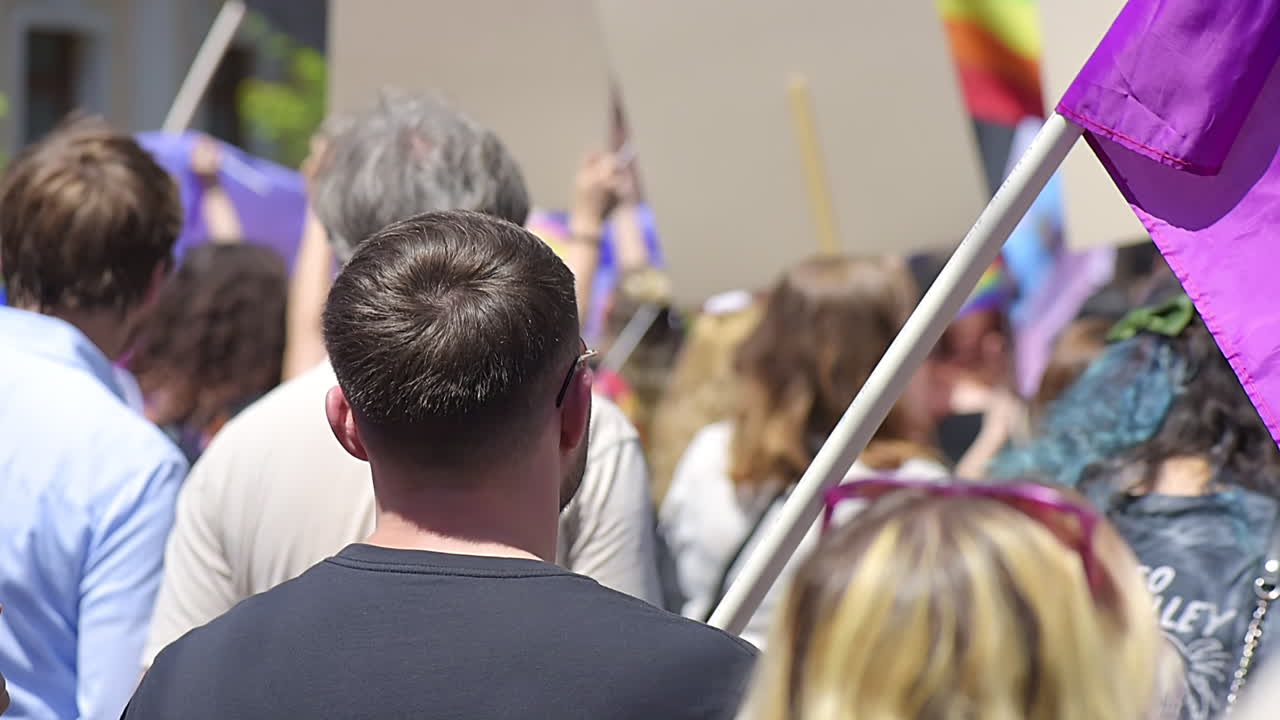 Tante persone al gay pride nel centro di Chișinău, Moldavia. Molte bandiere arcobaleno e poster. Rallentatore