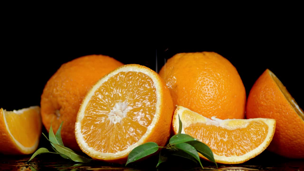 naranja fresca con hojas que caen gotas de agua.